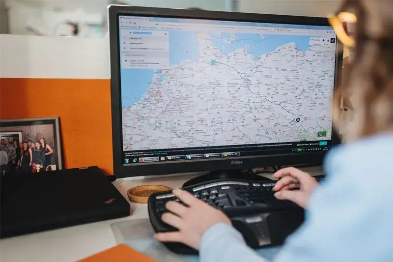 Spedytor w pracy przy komputerze z mapą